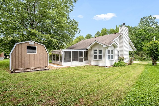 205 Blue Lake Dr, Tullahoma, TN 37388 - rear view of property with a sunroom, a storage unit, and a lawn