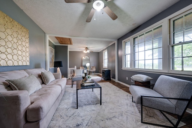 1529 W Grab Creek Rd, Dickson, TN 37055 - living room with a ceiling fan, a textured ceiling, wood finished floors, baseboards, and a wood stove