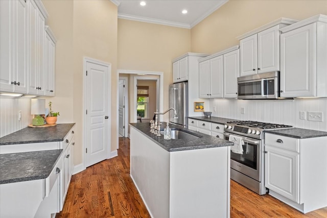 4145 Trinity Rd, Franklin, TN 37067 - kitchen with appliances with stainless steel finishes, a sink, a towering ceiling, a kitchen island with sink, and white cabinets