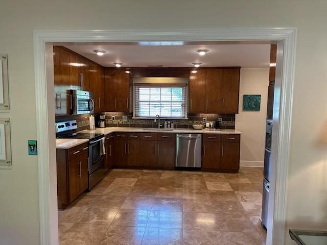 108 Sunset Dr, Pulaski, TN 38478 - kitchen with appliances with stainless steel finishes, a sink, backsplash, light countertops, and dark brown cabinetry