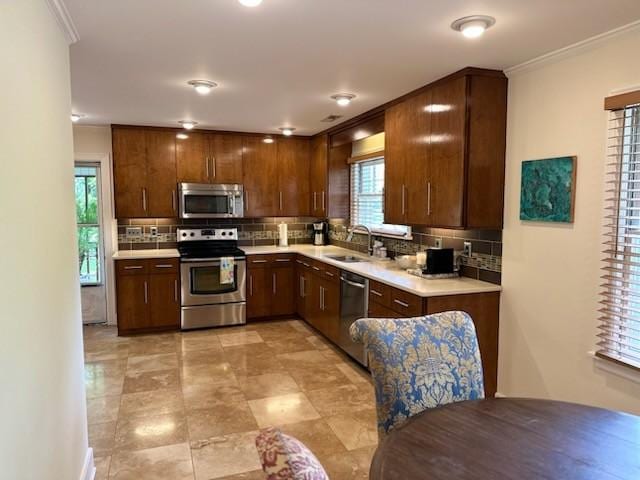 108 Sunset Dr, Pulaski, TN 38478 - kitchen featuring stainless steel appliances, tasteful backsplash, a sink, light countertops, and crown molding