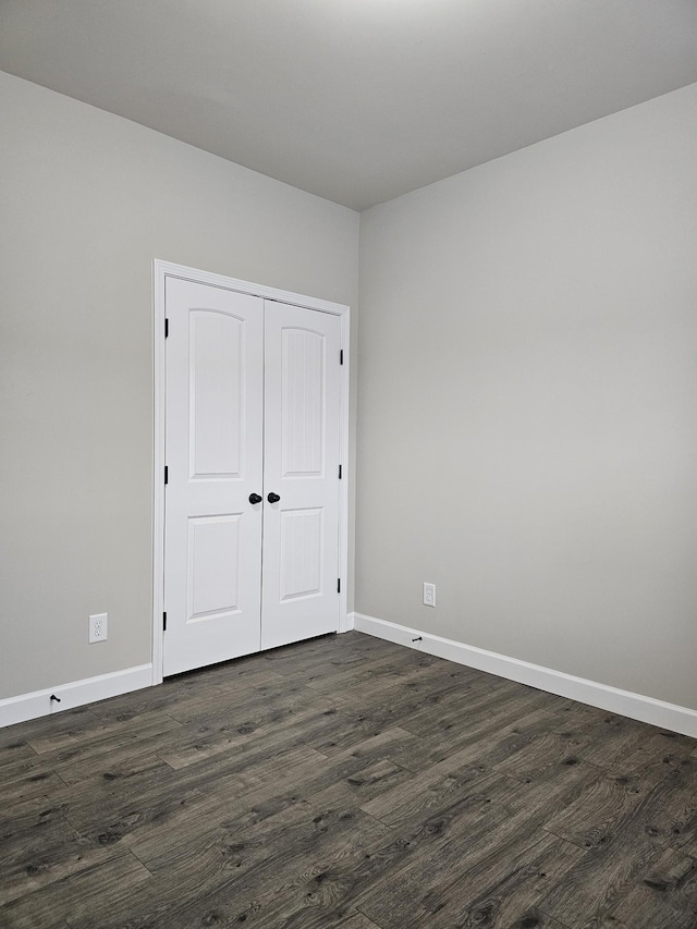 1040 Charlie Daniels Pkwy Unit 111, Mount Juliet, TN 37122 - unfurnished bedroom featuring dark wood-style flooring, baseboards, and a closet
