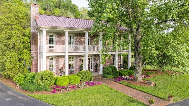 5620 Leipers Creek Rd, Franklin, TN 37064 - view of front of home with a balcony, brick siding, a front lawn, a standing seam roof, and a chimney