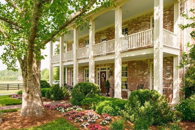 5620 Leipers Creek Rd, Franklin, TN 37064 - view of front of home with a balcony, brick siding, covered porch, and fence