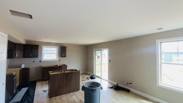 241 Cardinal Crk, Clarksville, TN 37040 - kitchen with light wood-style floors, a kitchen island, baseboards, and dark brown cabinetry