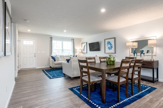 dining area featuring baseboards, recessed lighting, wood finished floors, and a textured ceiling