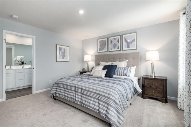 bedroom with carpet floors, baseboards, and connected bathroom