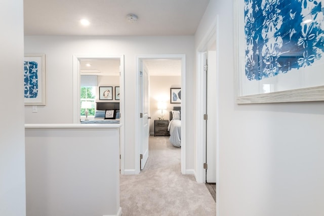 hallway with light carpet, baseboards, and recessed lighting