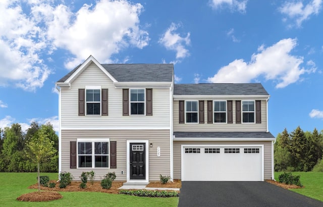 view of front of home with a garage, driveway, and a front lawn