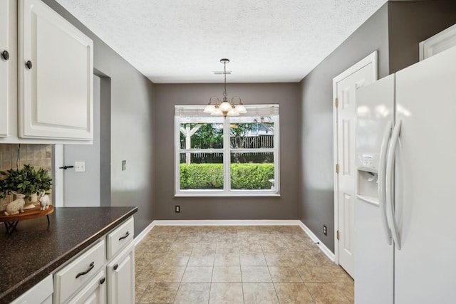 2981 Buckner Ln, Spring Hill, TN 37174 - kitchen with white fridge with ice dispenser, a chandelier, white cabinetry, a textured ceiling, and decorative light fixtures
