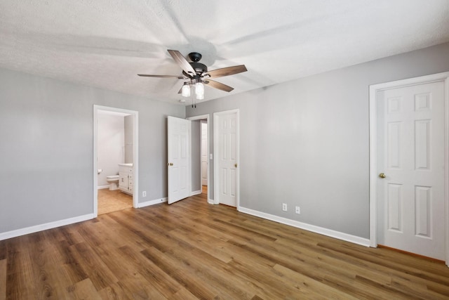 2981 Buckner Ln, Spring Hill, TN 37174 - unfurnished bedroom featuring wood finished floors, baseboards, connected bathroom, and ceiling fan