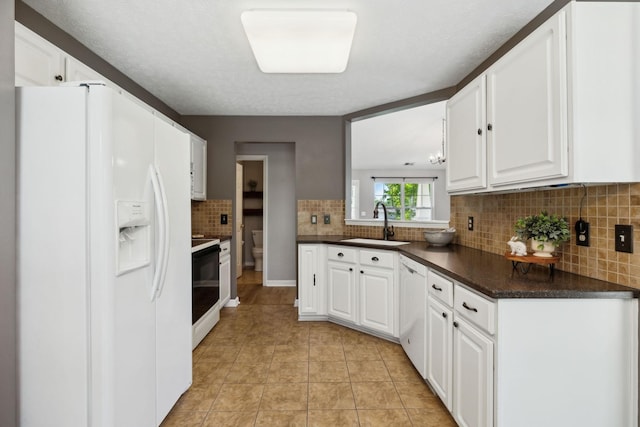 2981 Buckner Ln, Spring Hill, TN 37174 - kitchen featuring white appliances, a sink, dark countertops, decorative backsplash, and white cabinetry