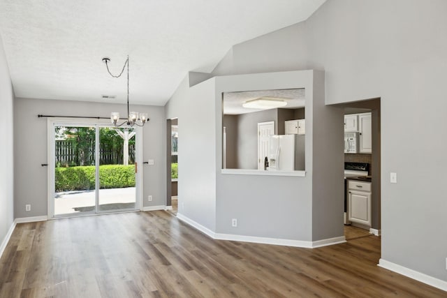 2981 Buckner Ln, Spring Hill, TN 37174 - unfurnished living room with wood finished floors, a chandelier, baseboards, and lofted ceiling