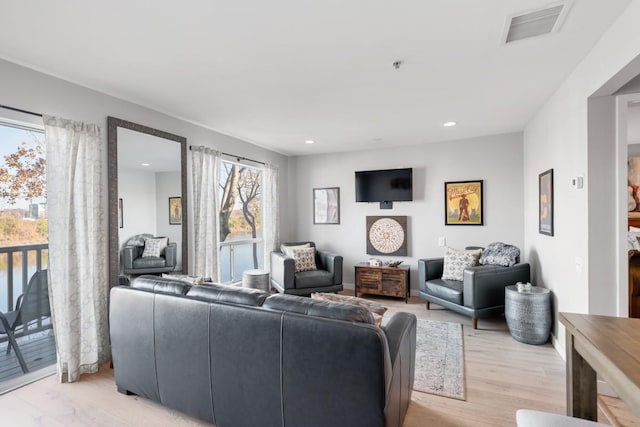 living area with light wood-style flooring and recessed lighting