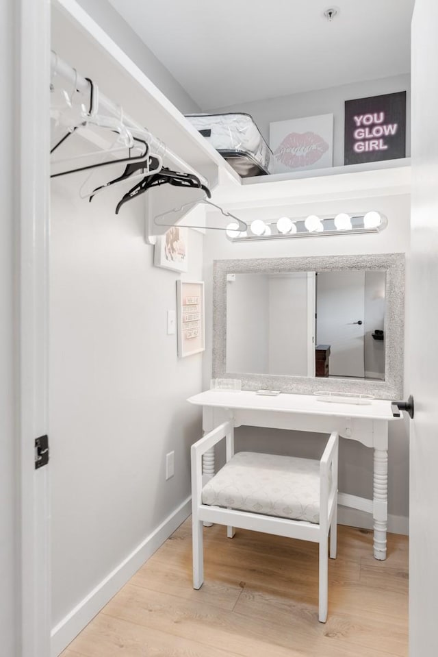 walk in closet with light wood-style floors