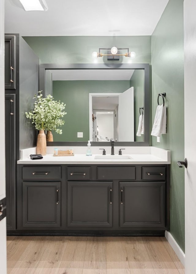 bathroom featuring vanity, wood finished floors, and baseboards
