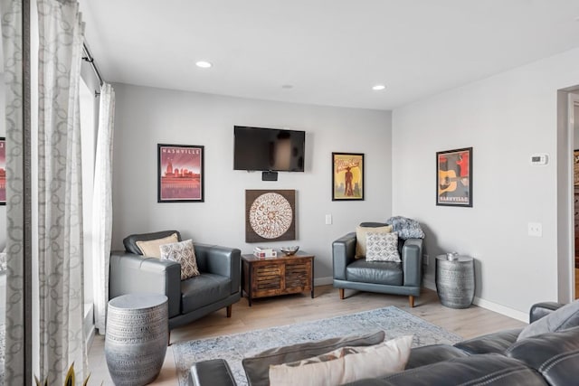 living area with wood finished floors, baseboards, and recessed lighting