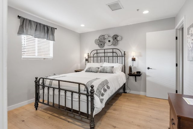 bedroom featuring wood finished floors, baseboards, and recessed lighting