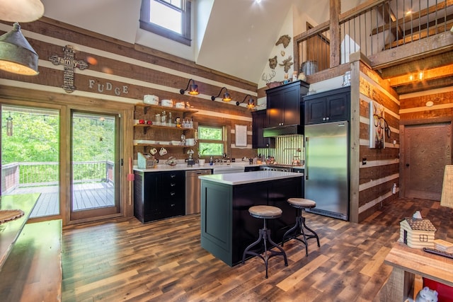 102 Highwater Rd, Waverly, TN 37185 - kitchen with stainless steel appliances, a towering ceiling, wooden walls, under cabinet range hood, and light countertops