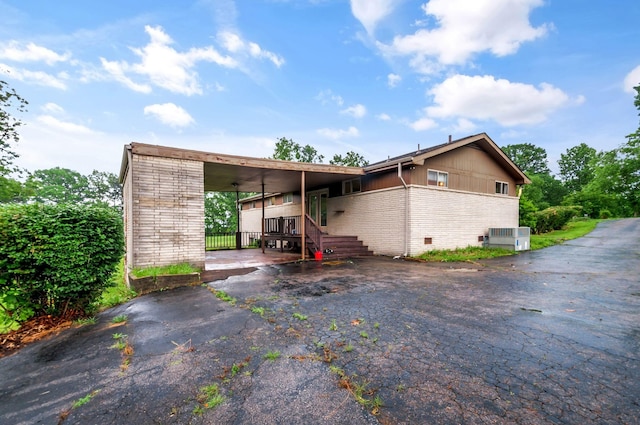1033 Pine Valley Rd, Kingston Springs, TN 37082 - view of front of home featuring driveway, an attached carport, brick siding, and central air condition unit