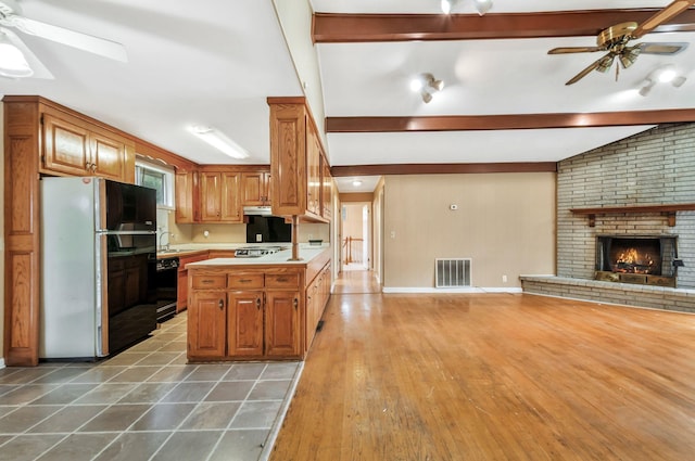 1033 Pine Valley Rd, Kingston Springs, TN 37082 - kitchen featuring a ceiling fan, freestanding refrigerator, open floor plan, beam ceiling, and a fireplace