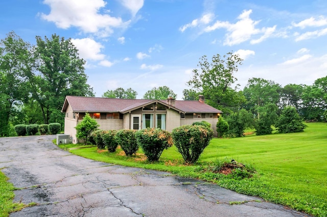 1033 Pine Valley Rd, Kingston Springs, TN 37082 - view of front of home with a chimney, a front lawn, brick siding, and asphalt driveway