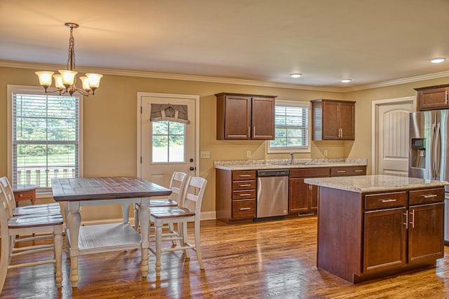 1570 Clemmons Rd, Cookeville, TN 38501 - kitchen featuring appliances with stainless steel finishes, a chandelier, wood finished floors, crown molding, and pendant lighting