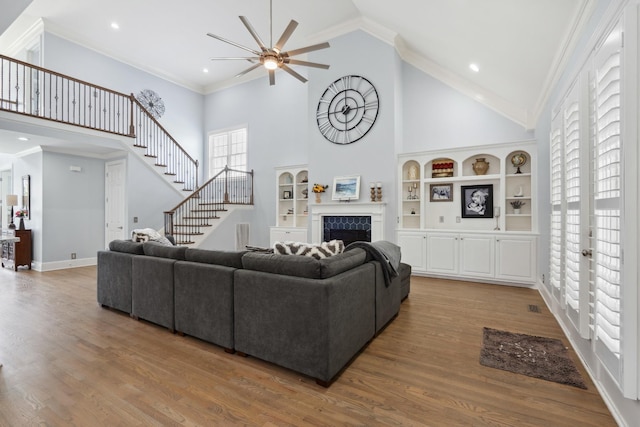 9702 Amethyst Ln, Brentwood, TN 37027 - living room featuring a ceiling fan, high vaulted ceiling, stairs, a fireplace, and wood finished floors