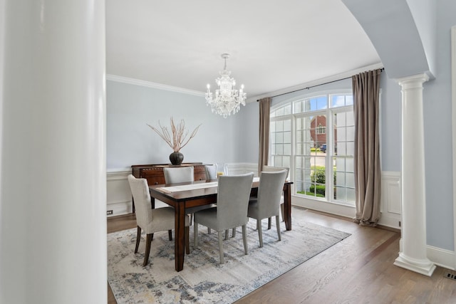 9702 Amethyst Ln, Brentwood, TN 37027 - dining room featuring decorative columns, arched walkways, healthy amount of natural light, a wainscoted wall, and ornamental molding