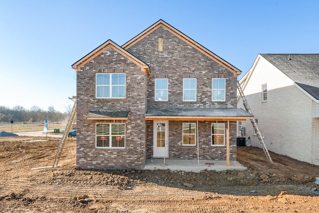 rear view of house with a patio area, brick siding, and cooling unit