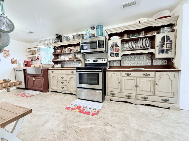 540 Grindstone Hollow Rd, Dickson, TN 37055 - kitchen featuring appliances with stainless steel finishes, open shelves, cream cabinetry, a sink, and dark countertops