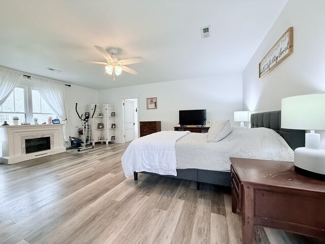 540 Grindstone Hollow Rd, Dickson, TN 37055 - bedroom with light wood finished floors, a ceiling fan, and a fireplace