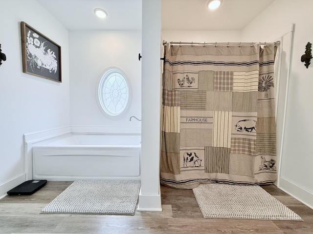 540 Grindstone Hollow Rd, Dickson, TN 37055 - bathroom featuring wood finished floors, a garden tub, and baseboards
