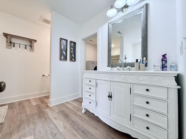 540 Grindstone Hollow Rd, Dickson, TN 37055 - bathroom with wood finished floors, vanity, washer / dryer, and baseboards