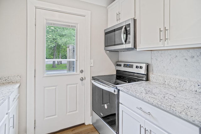 1301 Neelys Bend Rd Unit 50, Madison, TN 37115 - kitchen featuring stainless steel appliances, white cabinets, tasteful backsplash, light stone counters, and light wood-style floors
