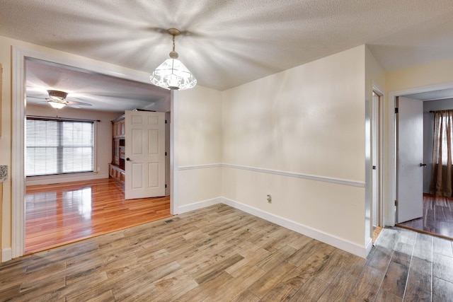 102 Hobbs Ridge Rd, Dunlap, TN 37327 - spare room with wood finished floors, baseboards, a textured ceiling, a chandelier, and a ceiling fan