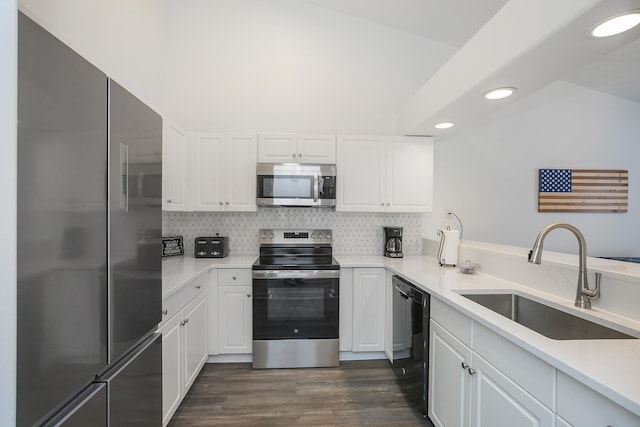kitchen featuring appliances with stainless steel finishes, a sink, recessed lighting, white cabinets, and dark wood-style floors