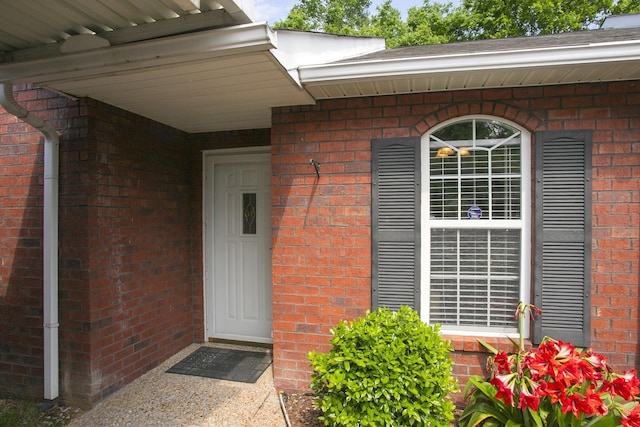 view of exterior entry featuring brick siding