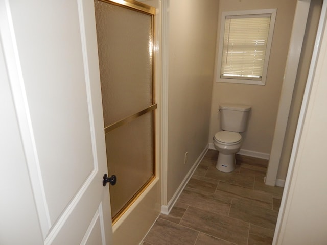 3355 Willie Mauldon Rd, Lutts, TN 38471 - bathroom featuring toilet, baseboards, and shower / bath combination with glass door