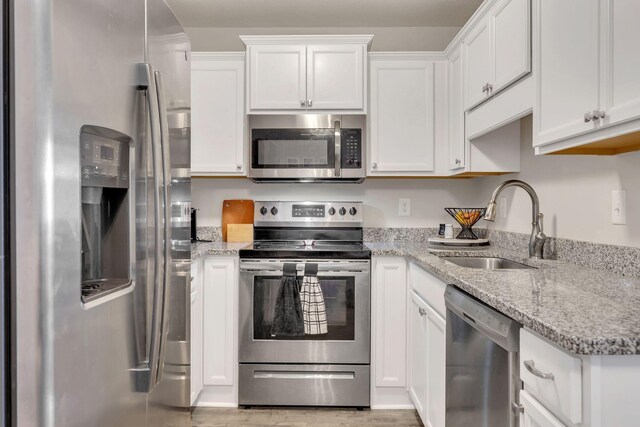 3507 Learning Ln, Murfreesboro, TN 37128 - kitchen with stainless steel appliances, a sink, white cabinetry, light wood-style floors, and light stone countertops