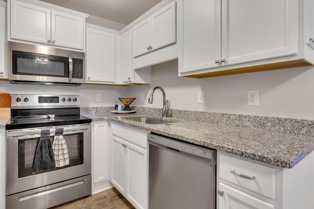 3507 Learning Ln, Murfreesboro, TN 37128 - kitchen featuring appliances with stainless steel finishes, a sink, white cabinets, light stone countertops, and light wood-style flooring