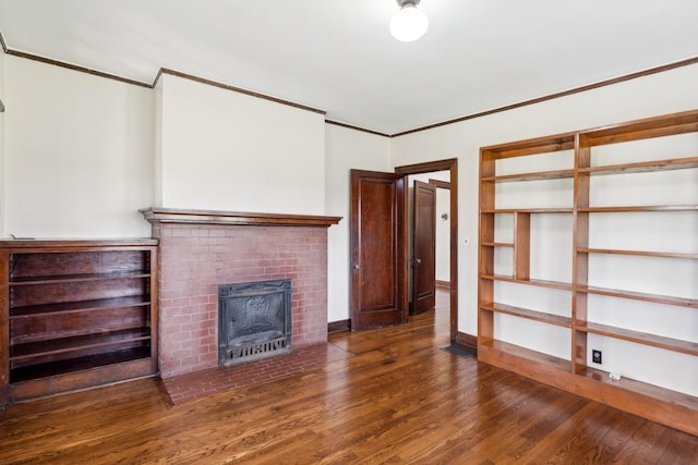 unfurnished living room with wood finished floors, ornamental molding, a fireplace, and baseboards