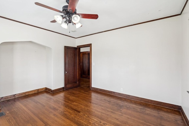 empty room with baseboards, ceiling fan, wood finished floors, and ornamental molding