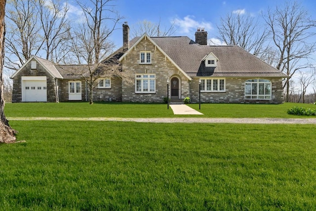 view of front of property with a chimney, a front yard, stone siding, and a garage