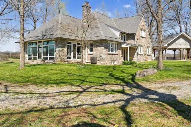 back of property featuring a chimney, a sunroom, stone siding, and a lawn