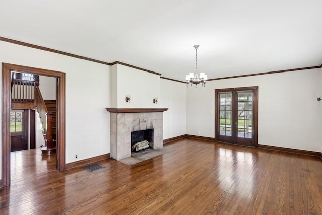 unfurnished living room featuring a chandelier, wood finished floors, plenty of natural light, and crown molding