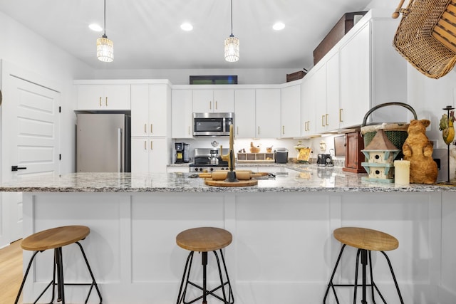 726 Morgan Ave, Woodbury, TN 37190 - kitchen featuring appliances with stainless steel finishes, a peninsula, a kitchen bar, and recessed lighting