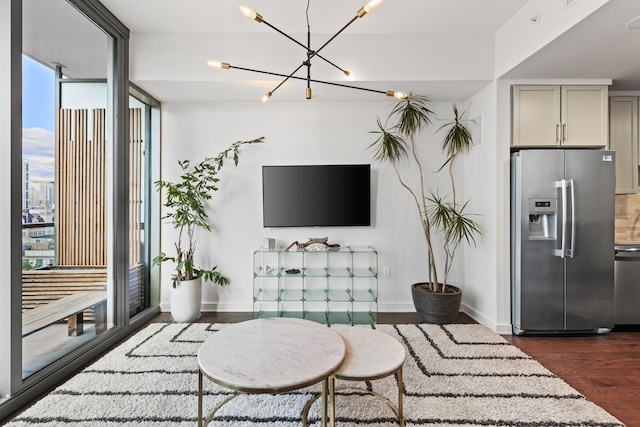 living room featuring dark wood finished floors, a chandelier, and baseboards