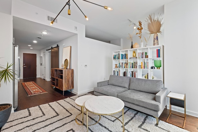 living room featuring a barn door, wood finished floors, baseboards, and recessed lighting