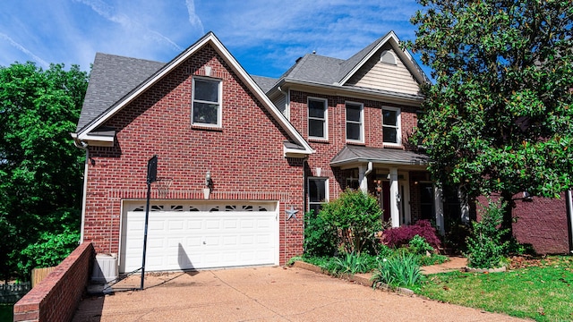 view of front facade featuring brick siding, driveway, and an attached garage